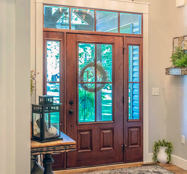 A wooden door with a wreath on it is in a hallway.