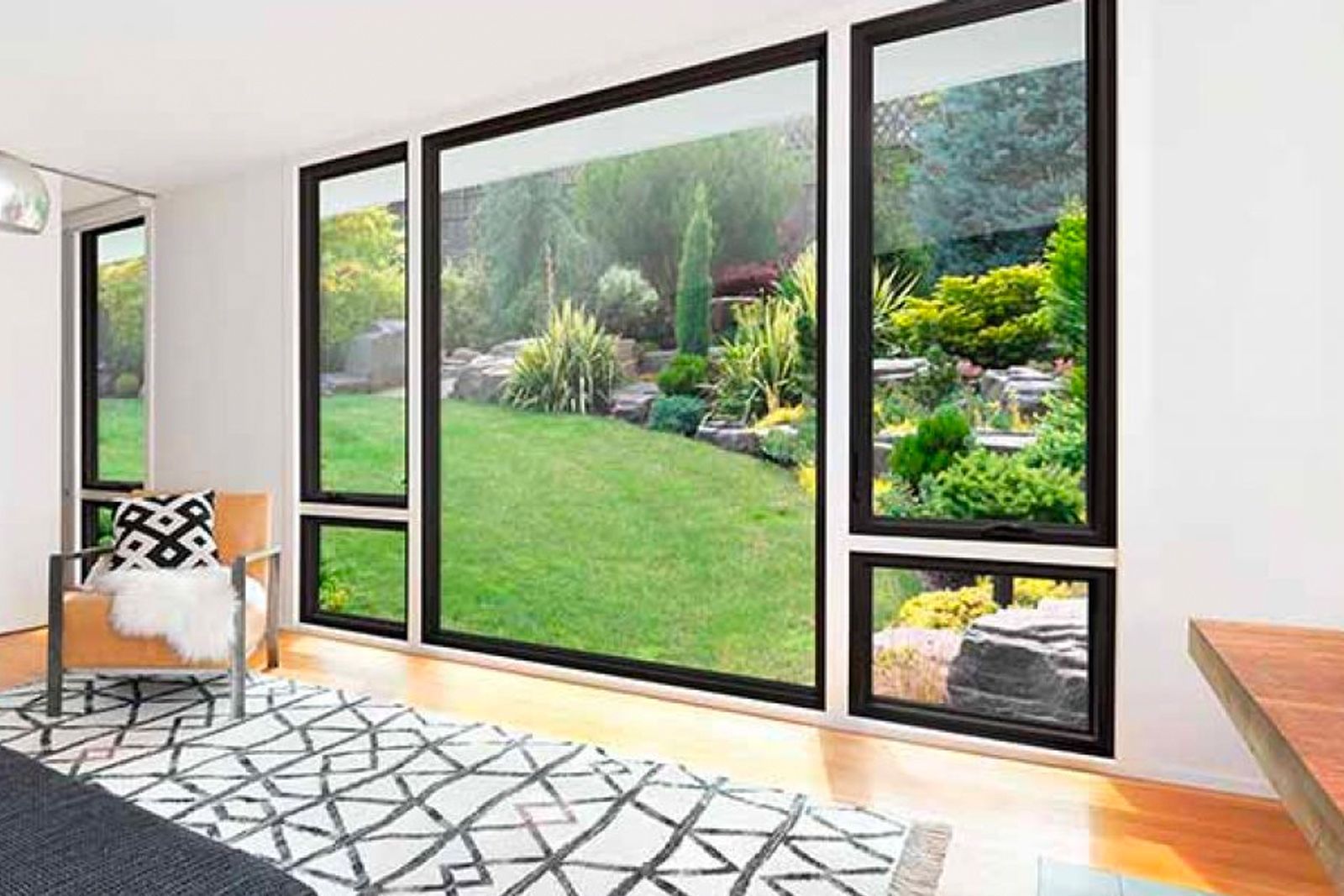 A living room with a large window looking out to a lush green yard.