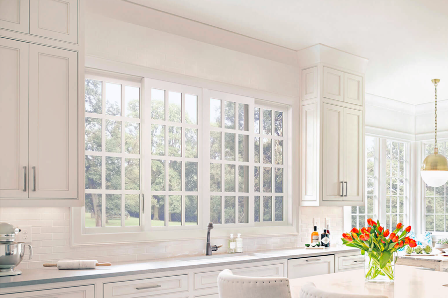 A kitchen with white cabinets and a vase of flowers on the counter.