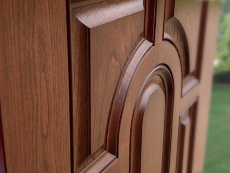 A close up of a wooden door with a design on it.