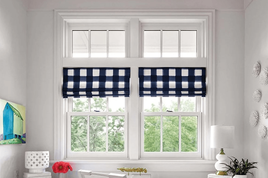 There are two windows in the room with blue and white checkered blinds.