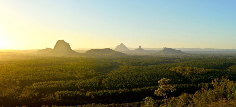A Sunset Over a Lush Green Forest With Mountains in the Background — Pools By Design in Beerwah, QLD