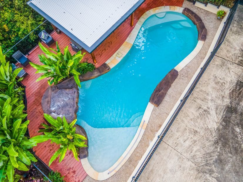An Aerial View of a Large Swimming Pool Surrounded by Trees — Pools By Design in Warana, QLD
