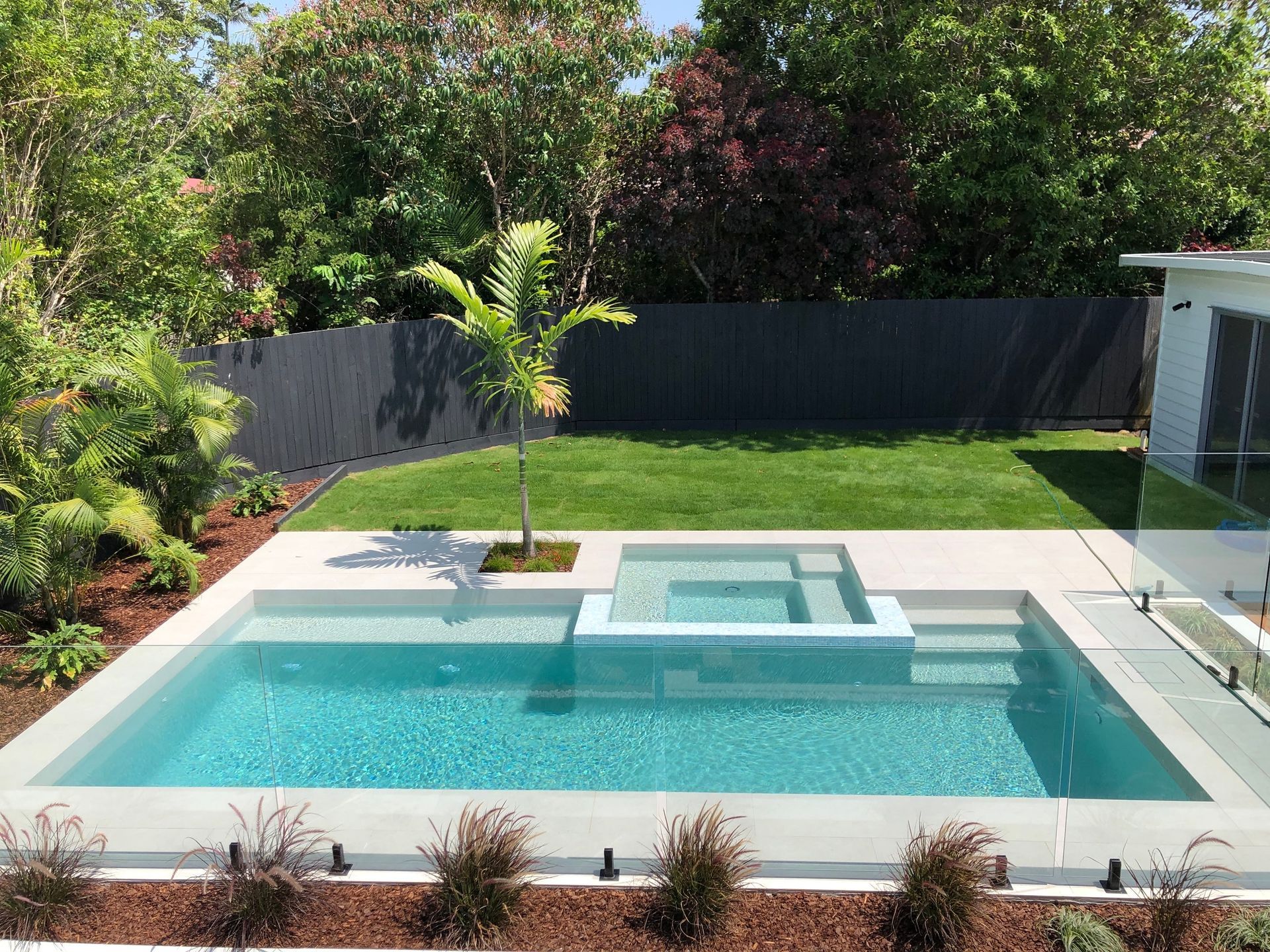 There is a Large Swimming Pool in the Backyard of a House — Pools By Design in Warana, QLD