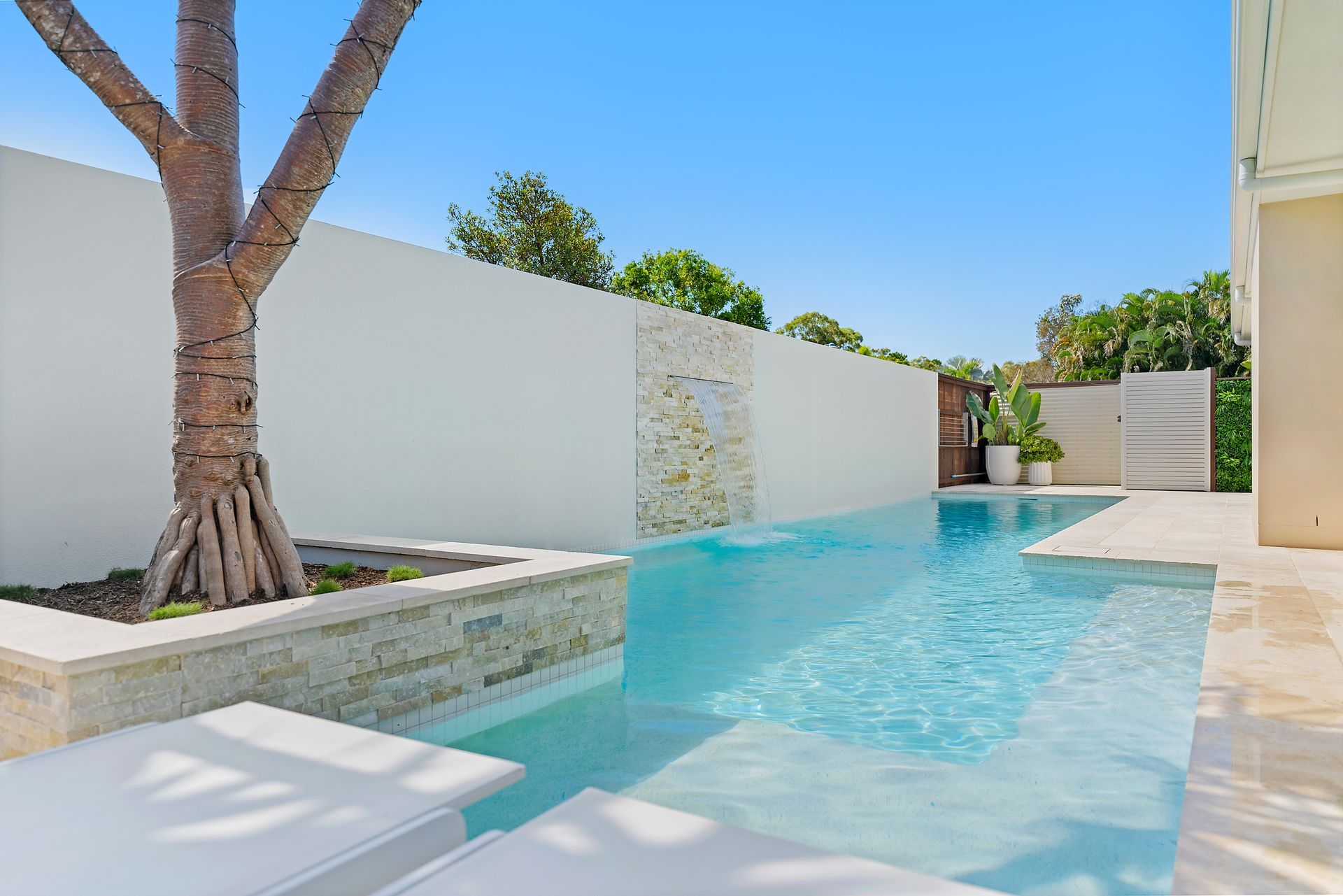 An Aerial View of a House With a Large Swimming Pool in Front of It — Pools By Design in Warana, QLD