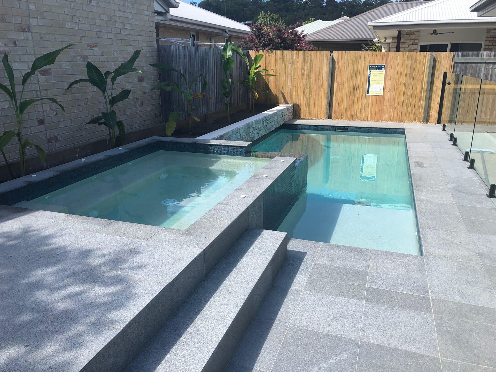 A Large Swimming Pool With Stairs Leading to It in a Backyard — Pools By Design in Warana, QLD