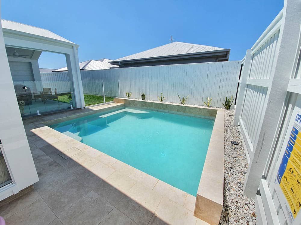A Small Swimming Pool in the Backyard of a House — Pools By Design in Warana, QLD