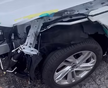 A close up of a damaged car 's fender and tire | AP Autohouse