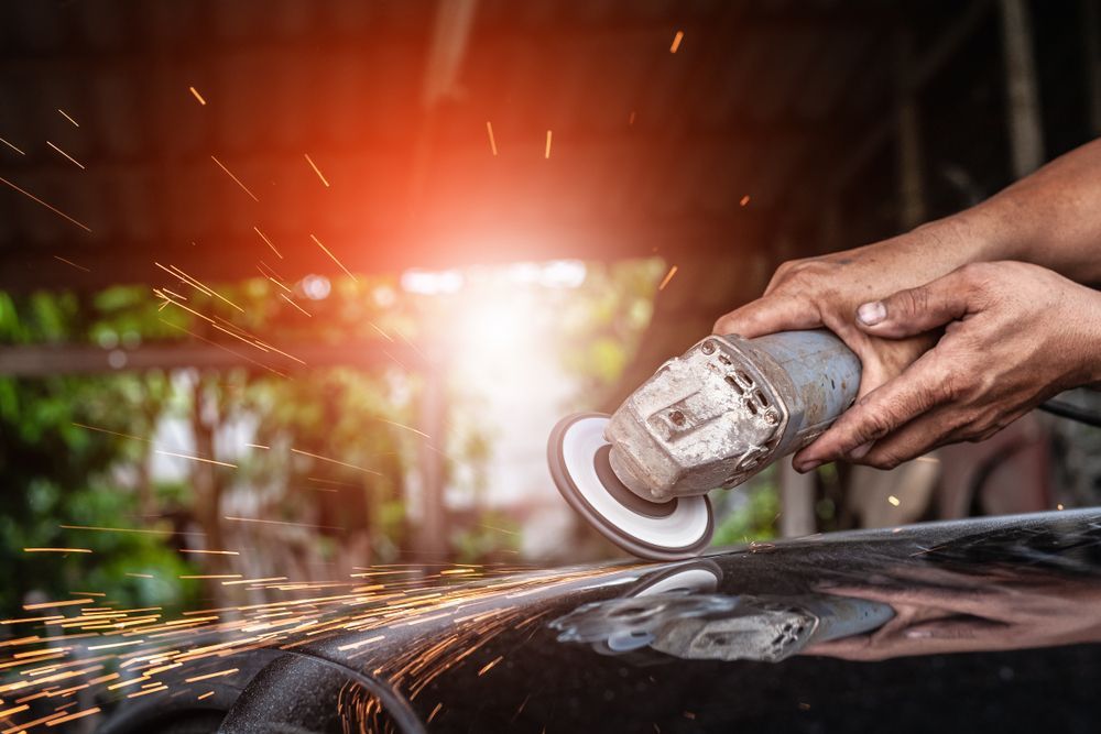 Person Using a Grinder, Creating Sparks, Likely Smoothing or Shaping Metal — Airlie Beach Smash Repairs in Bowen, QLD