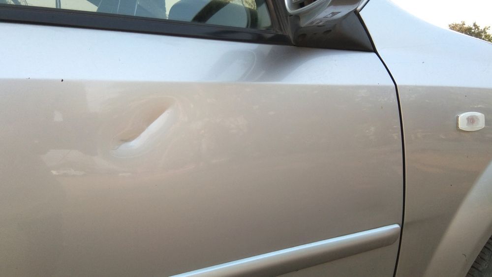 Silver Car Door With a Large Dent — Airlie Beach Smash Repairs in Cannonvale, QLD