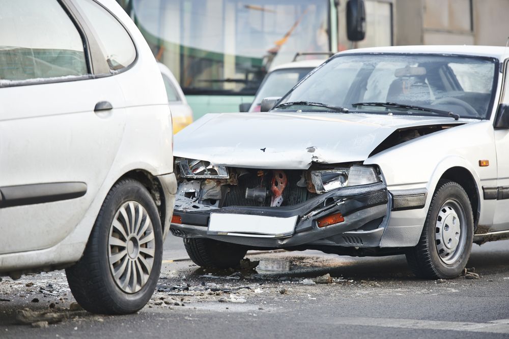 Two White Cars Involved in a Collision; One Severely Damaged in the Front — Airlie Beach Smash Repairs in Cannonvale, QLD