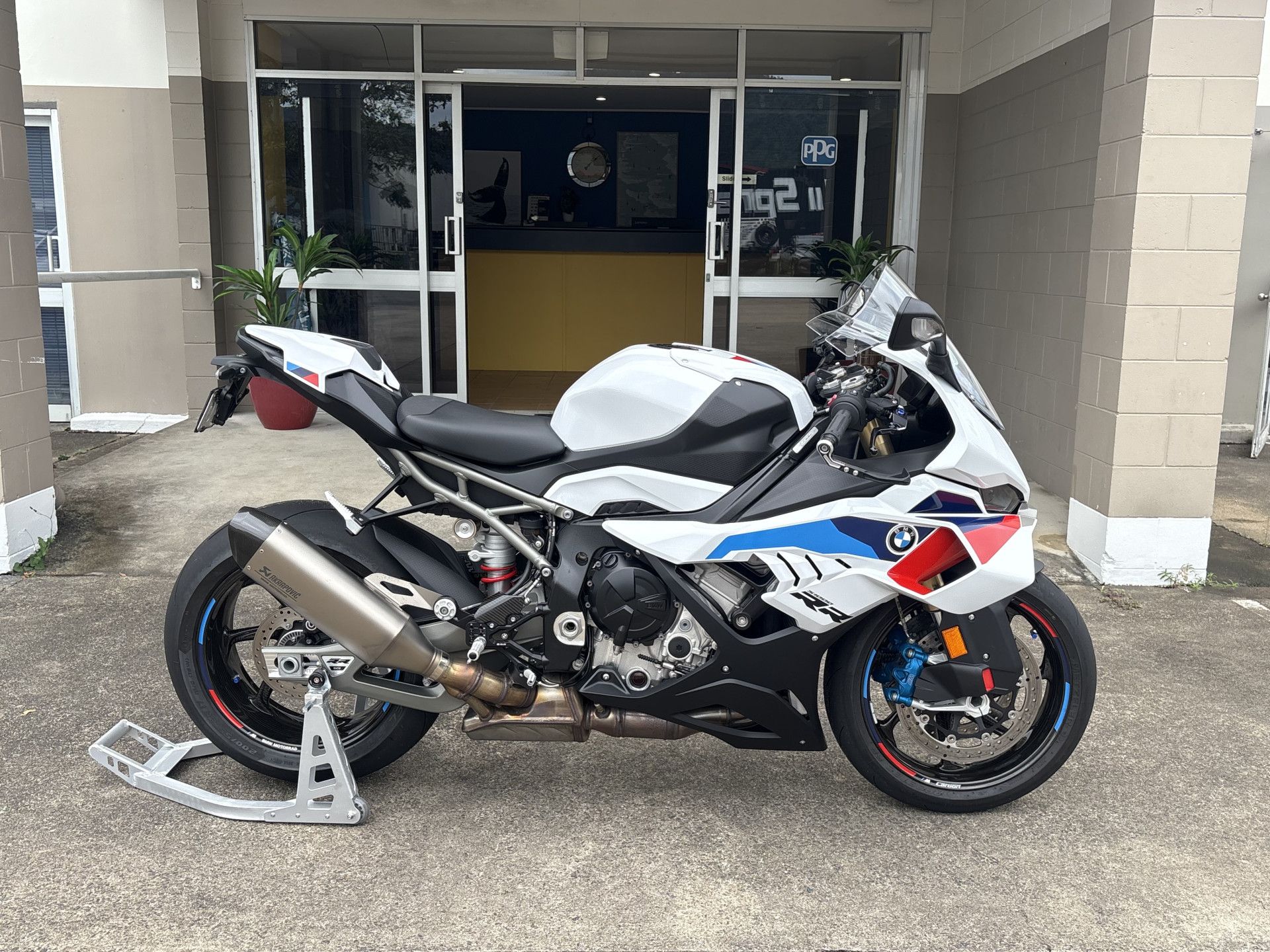 White, black, and blue BMW motorcycle parked outside a building.— Airlie Beach Smash Repairs in Cannonvale, QLD