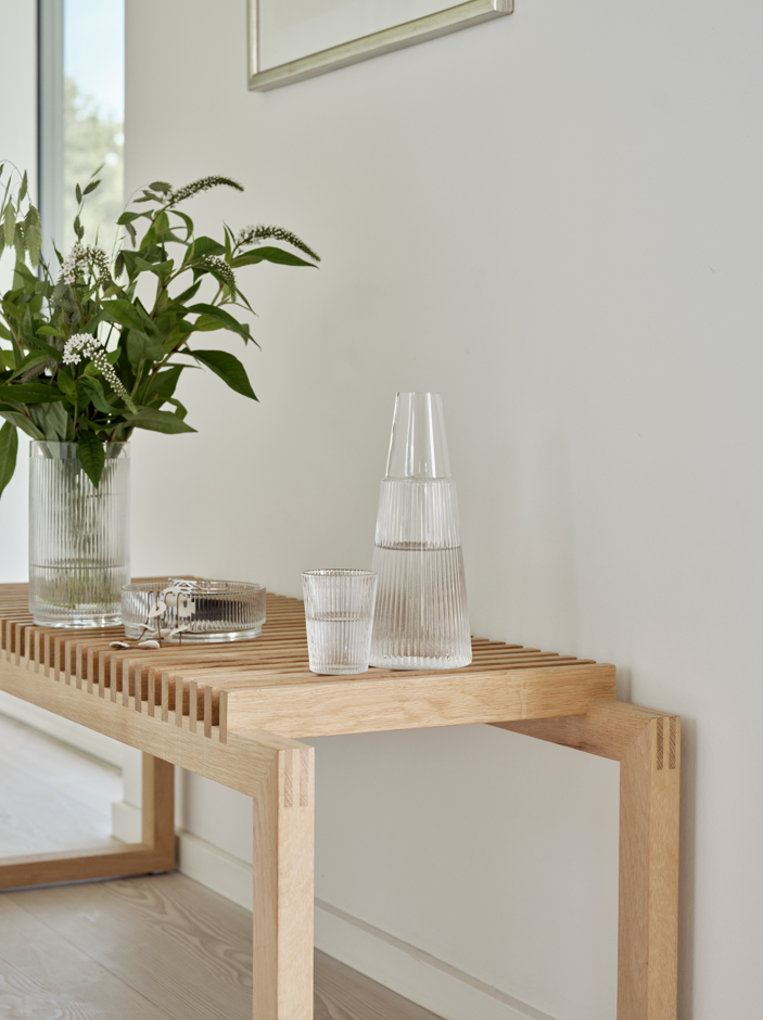 Ein Holztisch mit einer Vase mit Blumen darauf