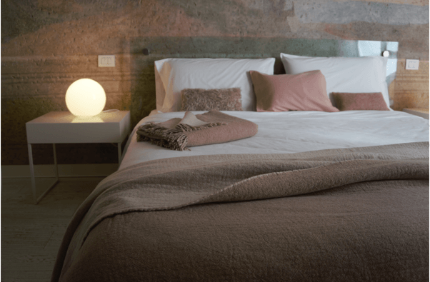 Ein Schlafzimmer mit Bett, Nachttisch und Lampe