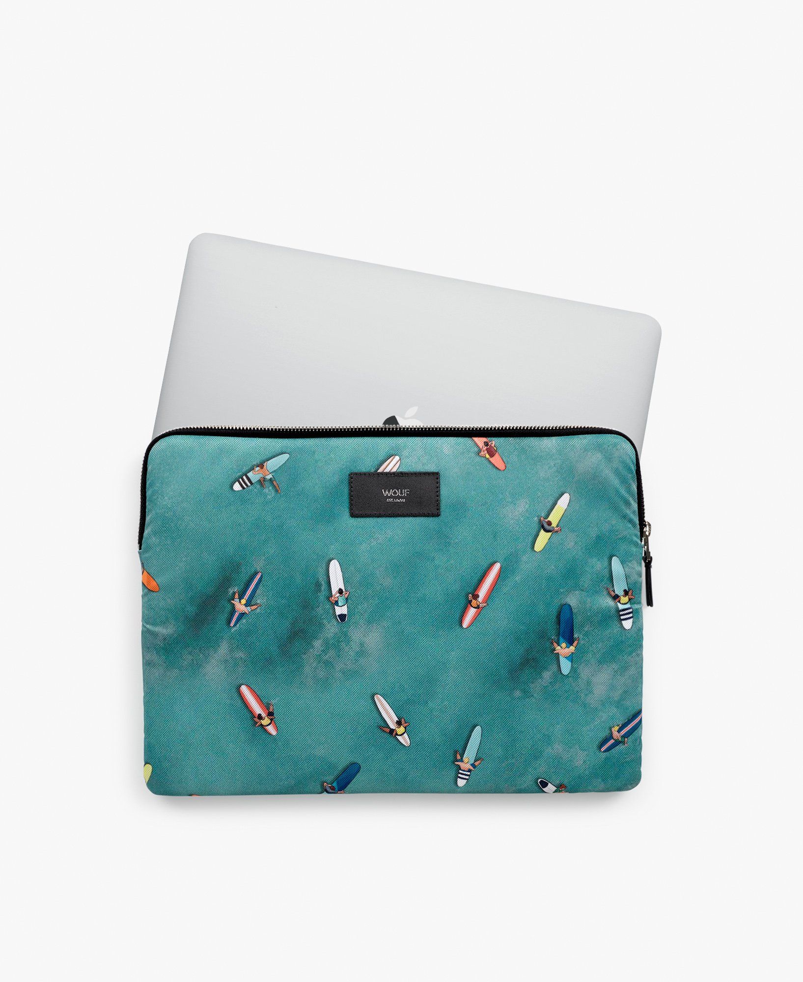 Ein Laptop liegt auf einer Laptoptasche mit Surfbrettern darauf.