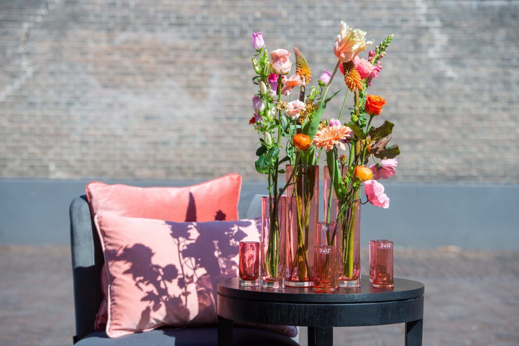 Ein Tisch mit Blumenvasen und Kerzen darauf.