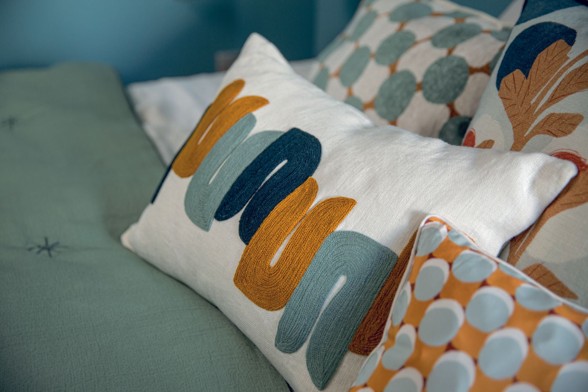 Ein Bett mit vielen bunten Kissen darauf.