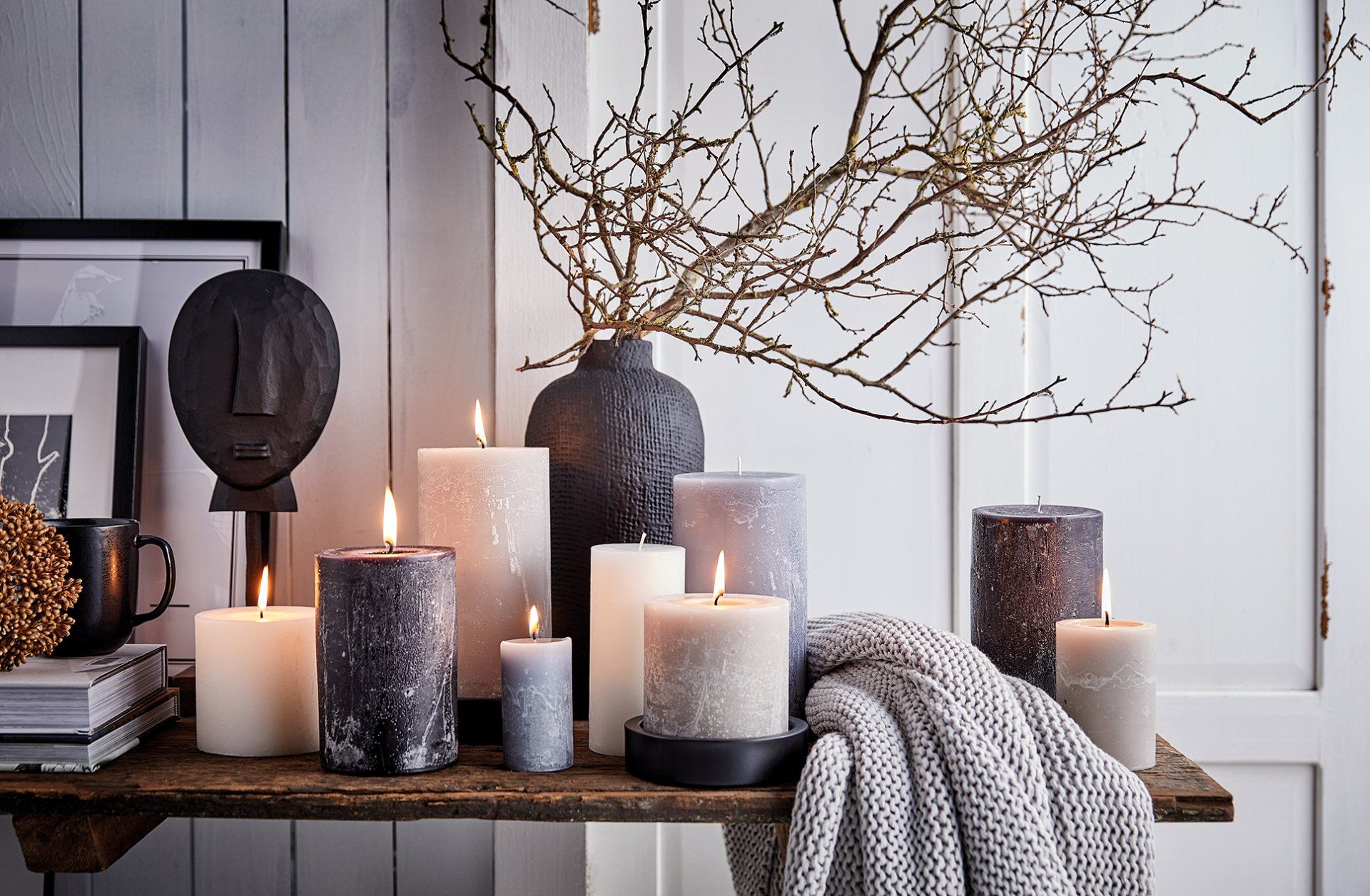 Ein Strauß Kerzen steht auf einem Holztisch.