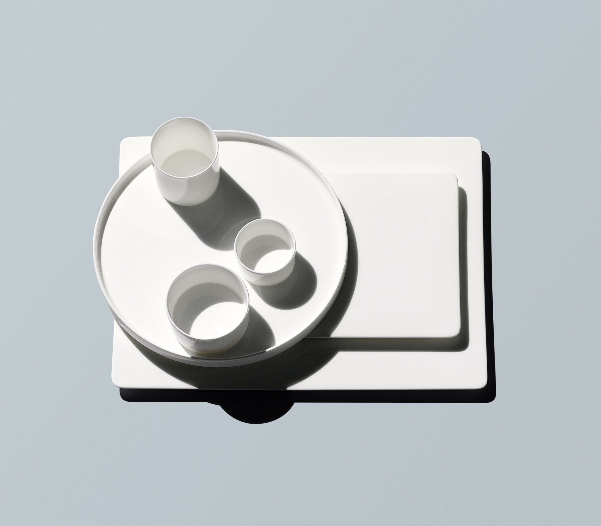 Ein weißes Tablett mit einer Schüssel und zwei Tassen darauf