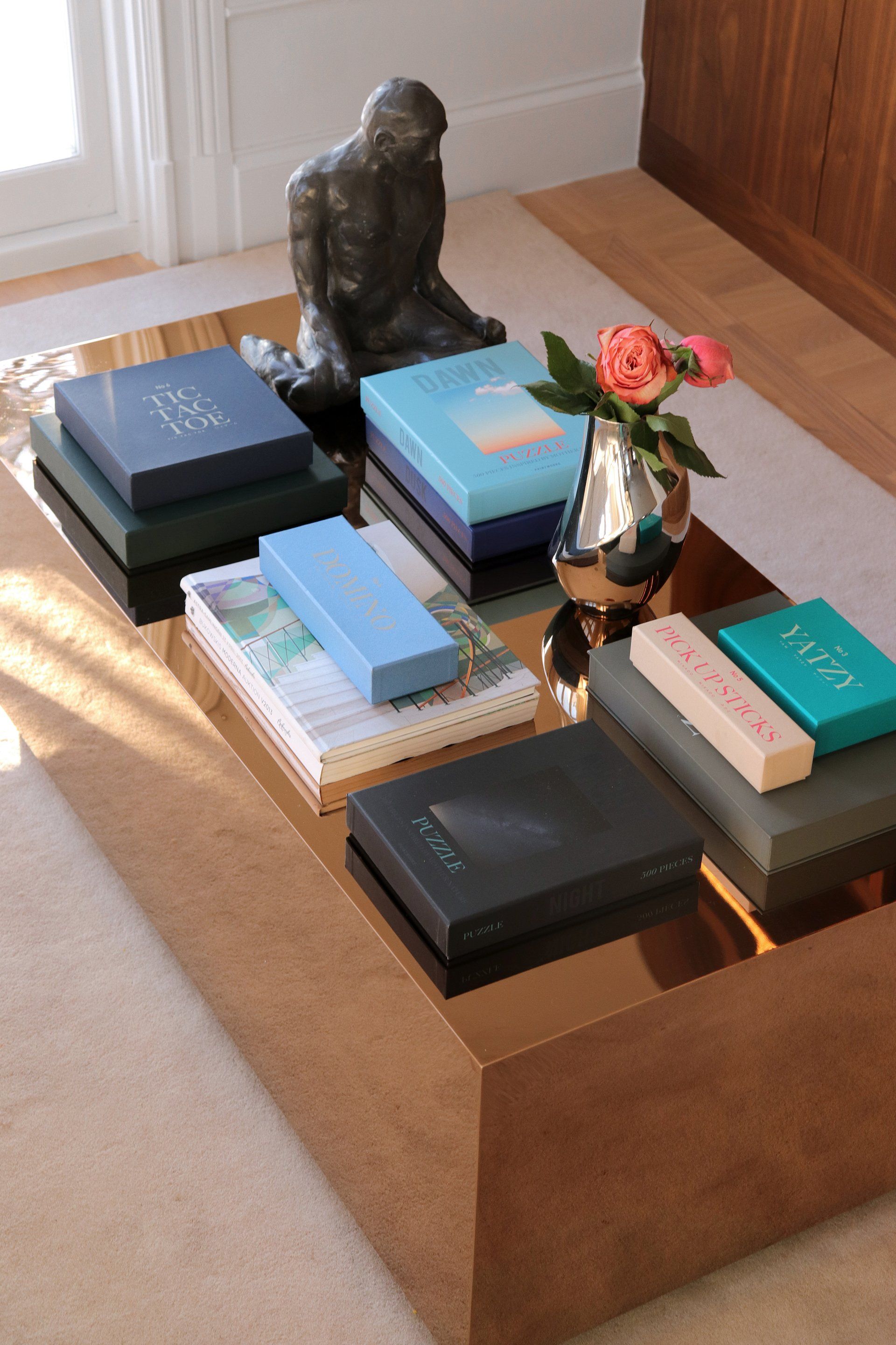 Ein Couchtisch mit Büchern und einer Vase mit Blumen darauf