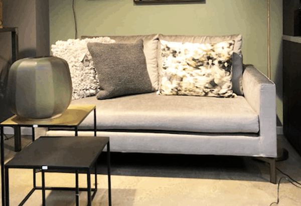 Ein Wohnzimmer mit einer Couch und zwei kleinen Tischen