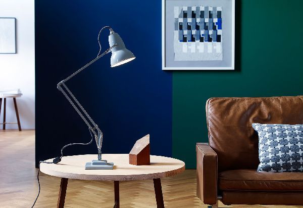 Eine Lampe steht auf einem Tisch in einem Wohnzimmer neben einer Couch.