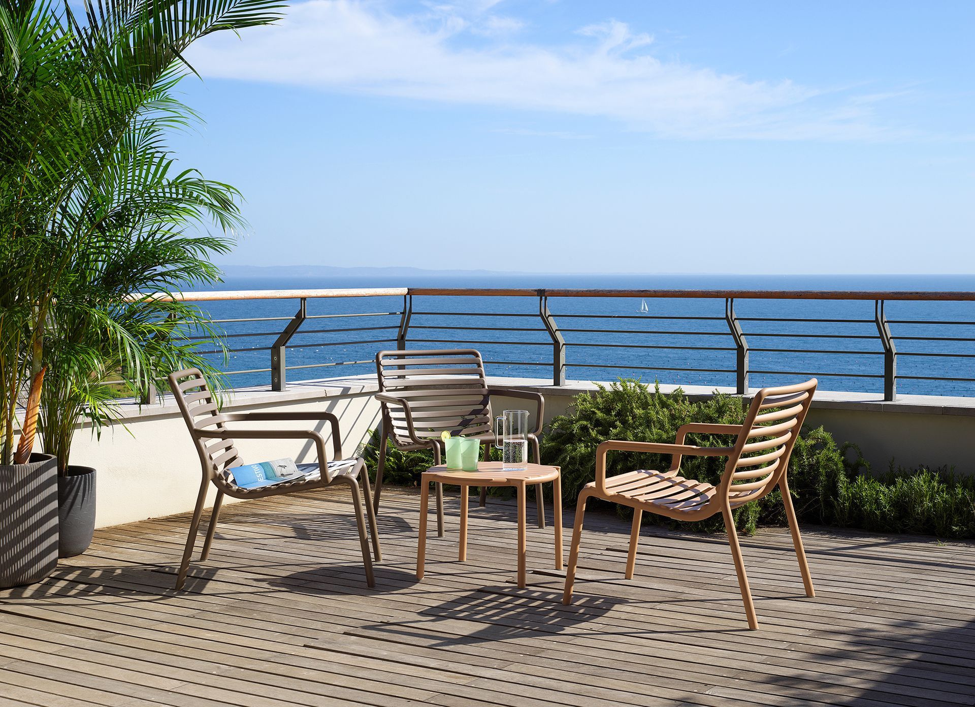 Ein Balkon mit Stühlen und einem Tisch mit Blick auf das Meer