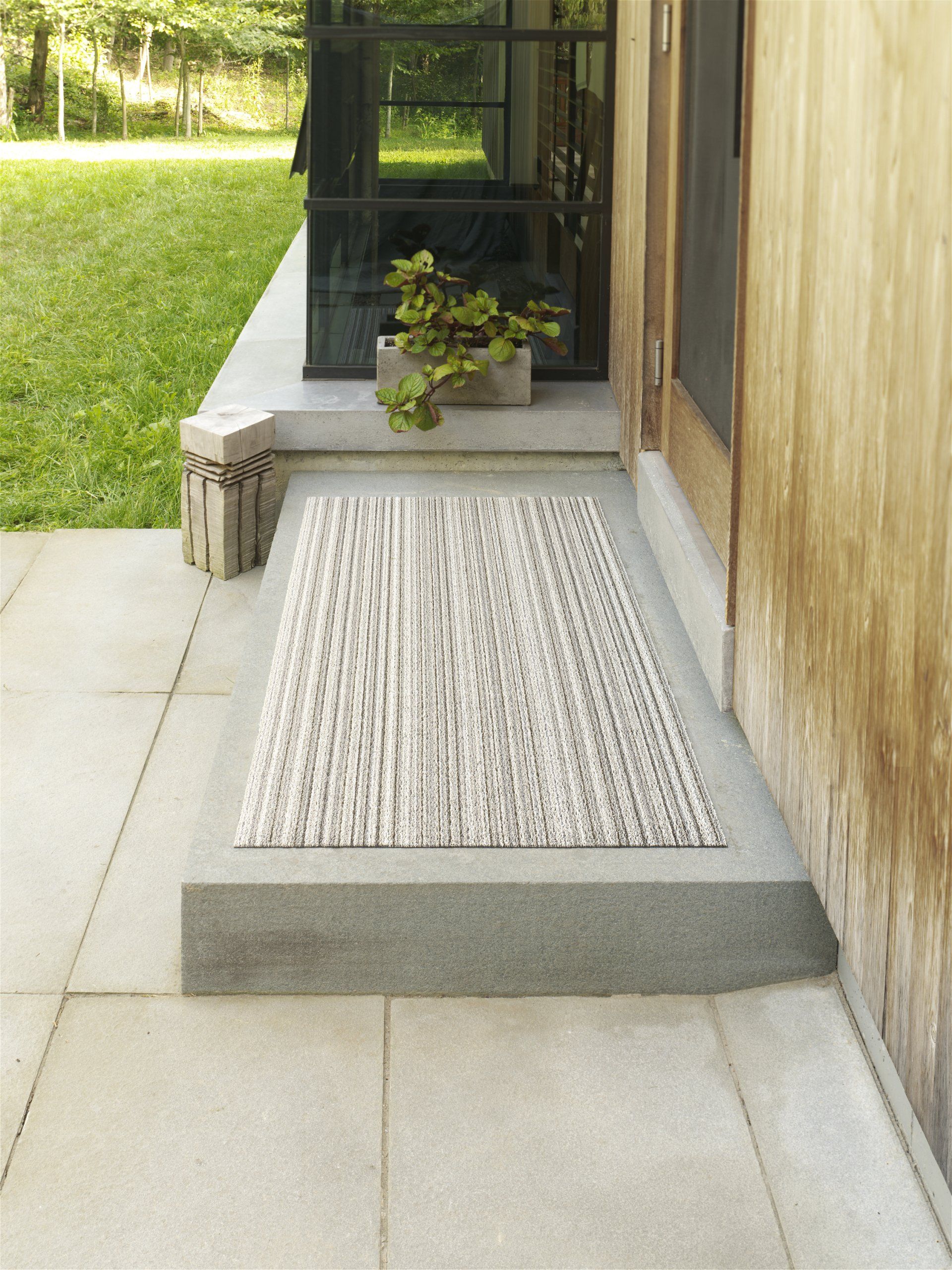 Auf dem Gehweg vor einem Haus liegt ein Teppich.