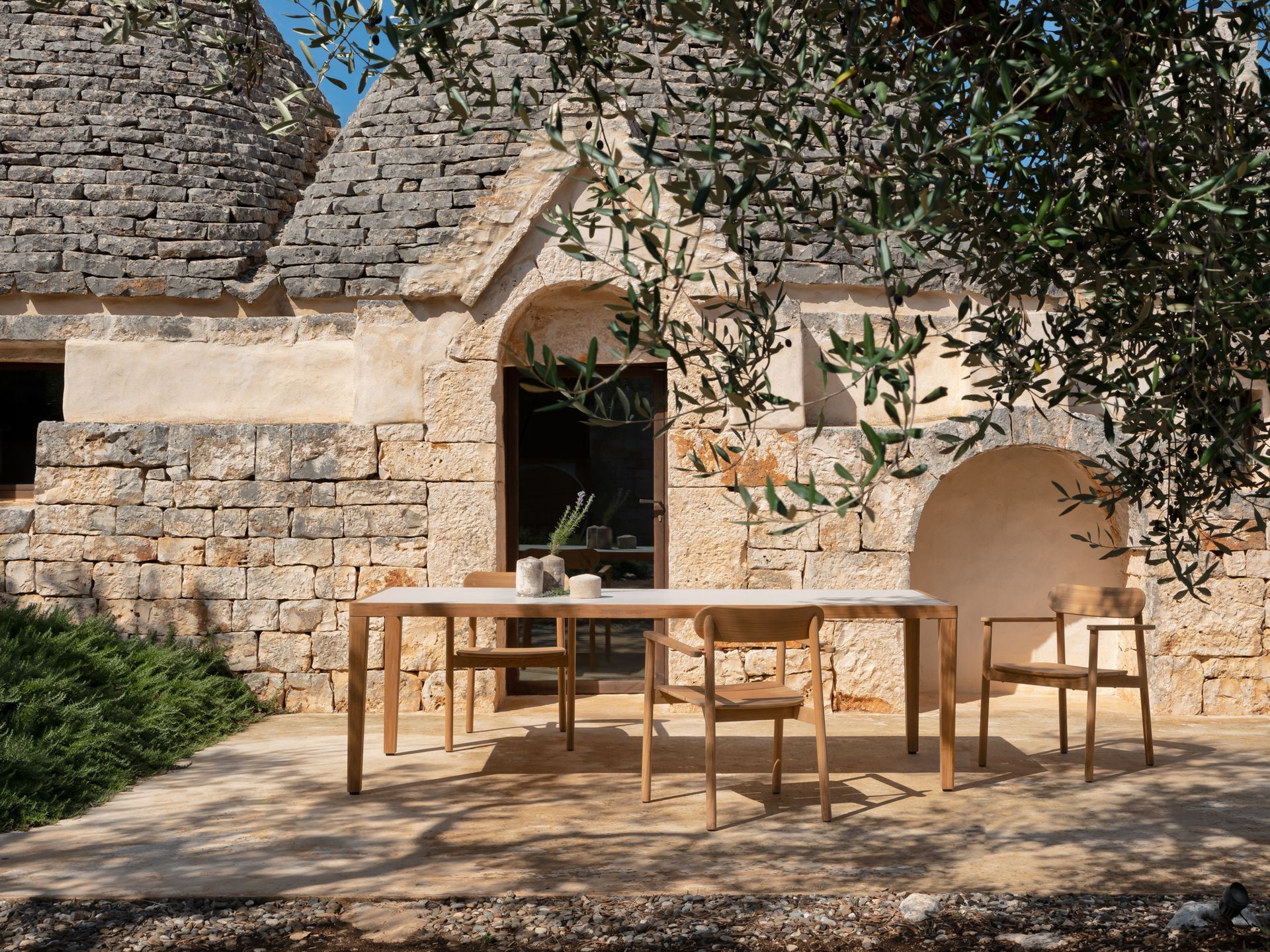 Eine Terrasse mit Tisch und Stühlen vor einem Backsteingebäude.
