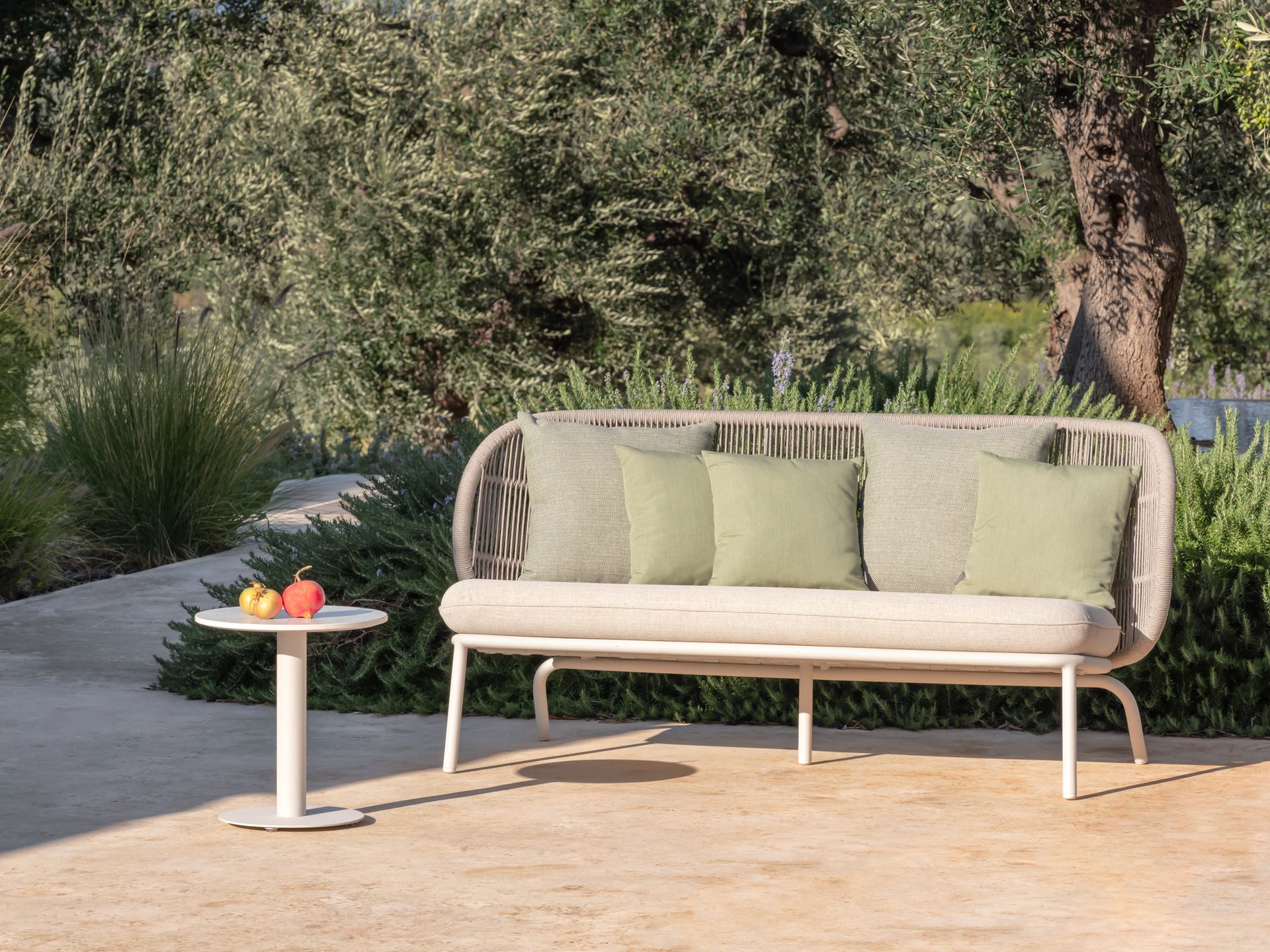 Auf einer Terrasse steht ein Sofa neben einem Tisch.