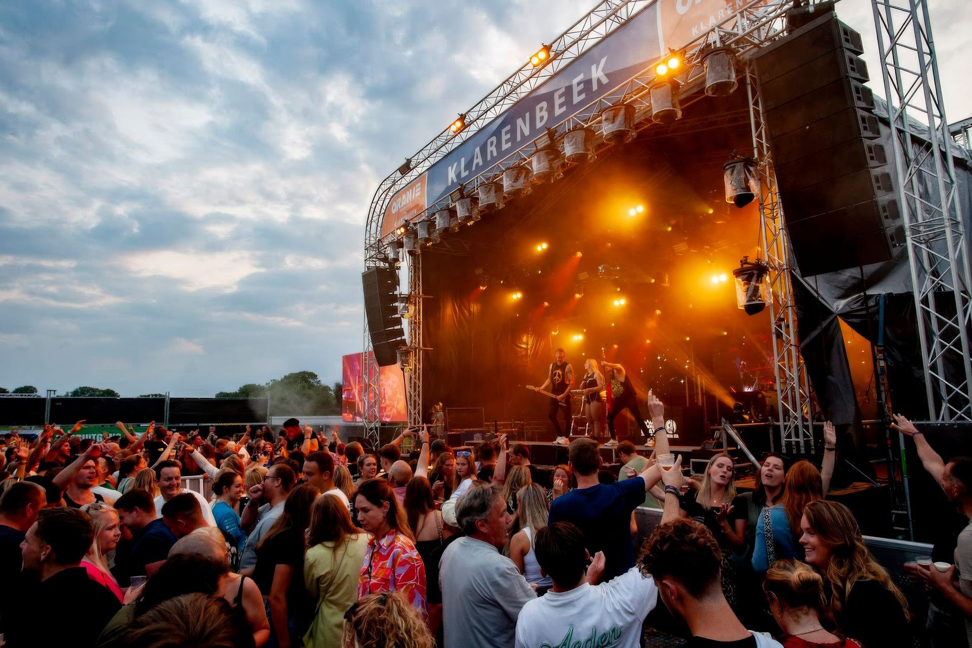 Mensenmenigte voor een podium op een festival.