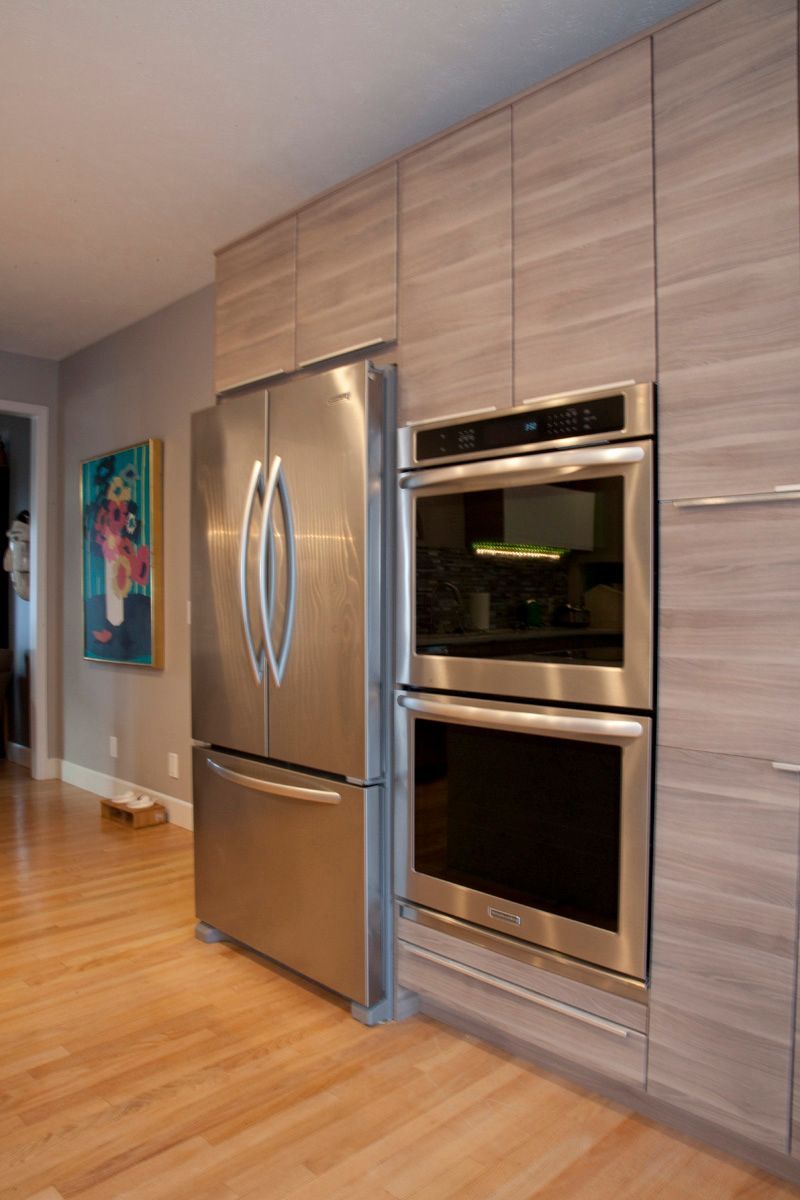 Modern kitchen with a wooden table, cooktop, and shelving with bottles. Modern kitchen with a wooden table, cooktop, and shelving with bottles.