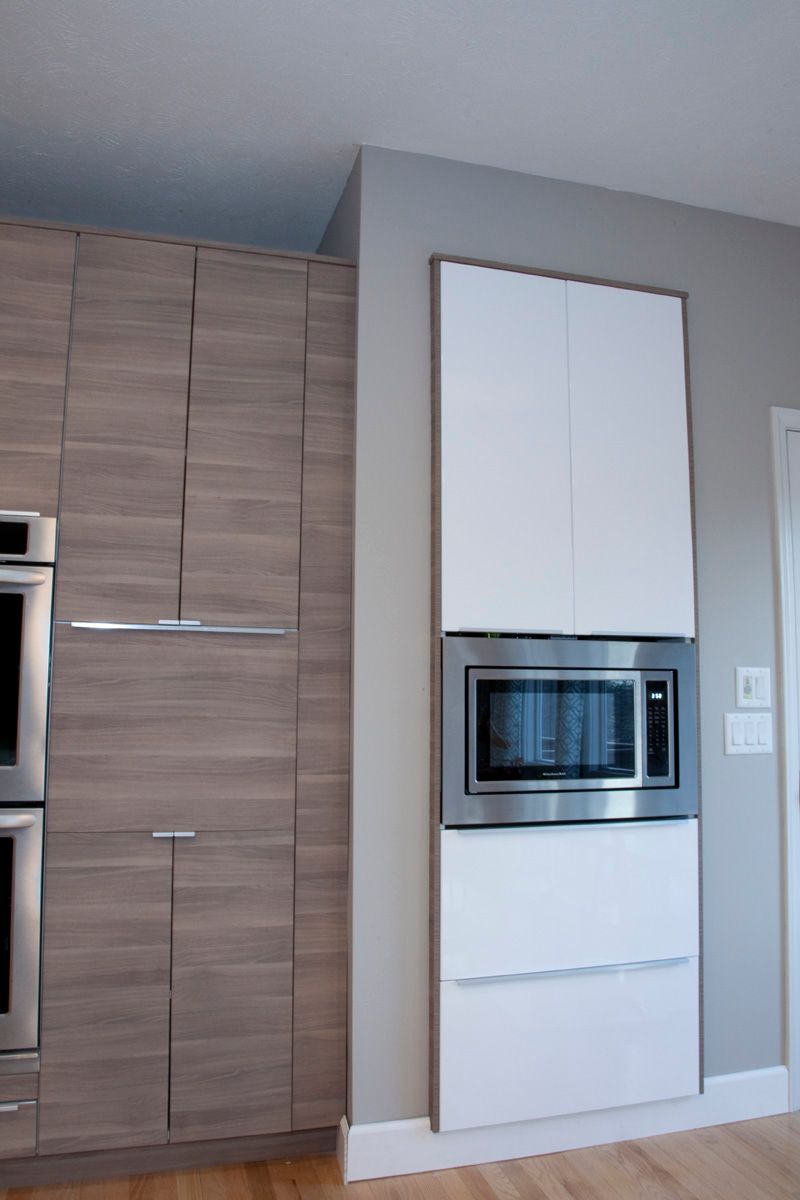 Kitchen with white cabinets, granite island, wooden floor, and windows. Kitchen with white cabinets, granite island, wooden floor, and windows.