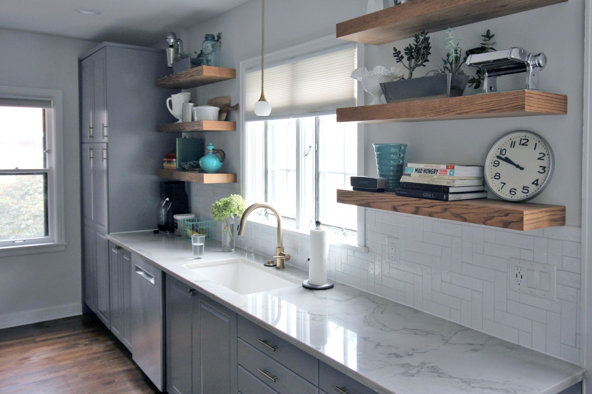 Modern kitchen with wood cabinets, island with stools, and black pendant lights. Modern kitchen with wood cabinets, island with stools, and black pendant lights.