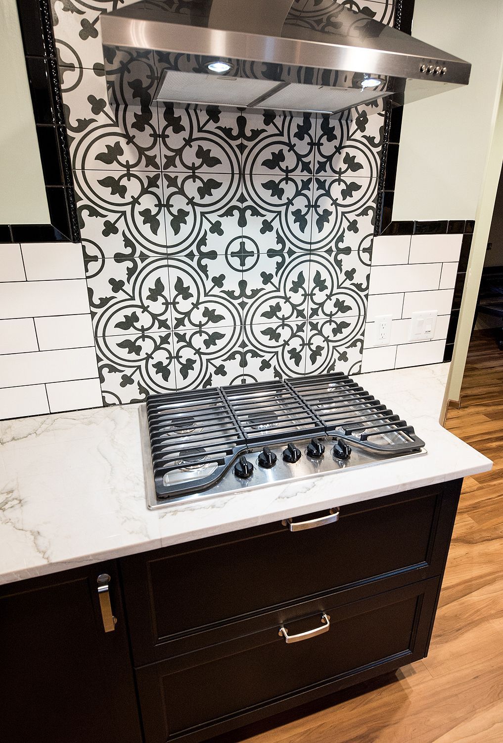 Kitchen with dark cabinets, white countertops, gas stovetop, and subway tile backsplash. Kitchen with dark cabinets, white countertops, gas stovetop, and subway tile backsplash.