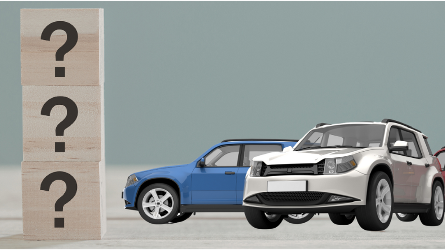 Two cars, a blue coupe behind a white SUV, beside stacked boxes with question marks