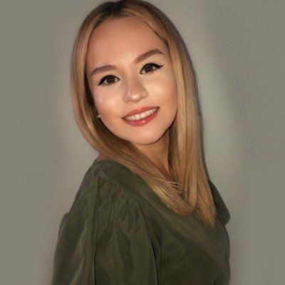 The woman is wearing a green shirt and smiling for the camera.