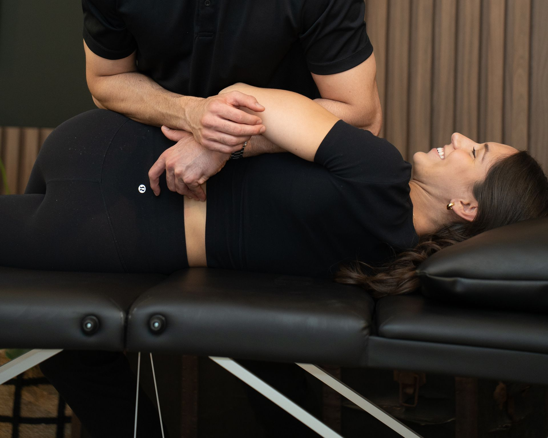 Person receiving a chiropractic adjustment on a black treatment table