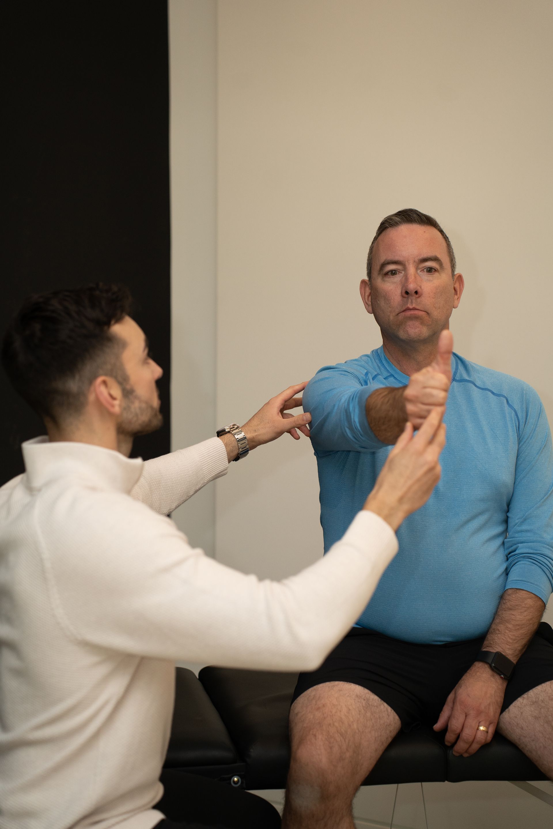 Physical therapist helping patient with arm exercises in a bright living room