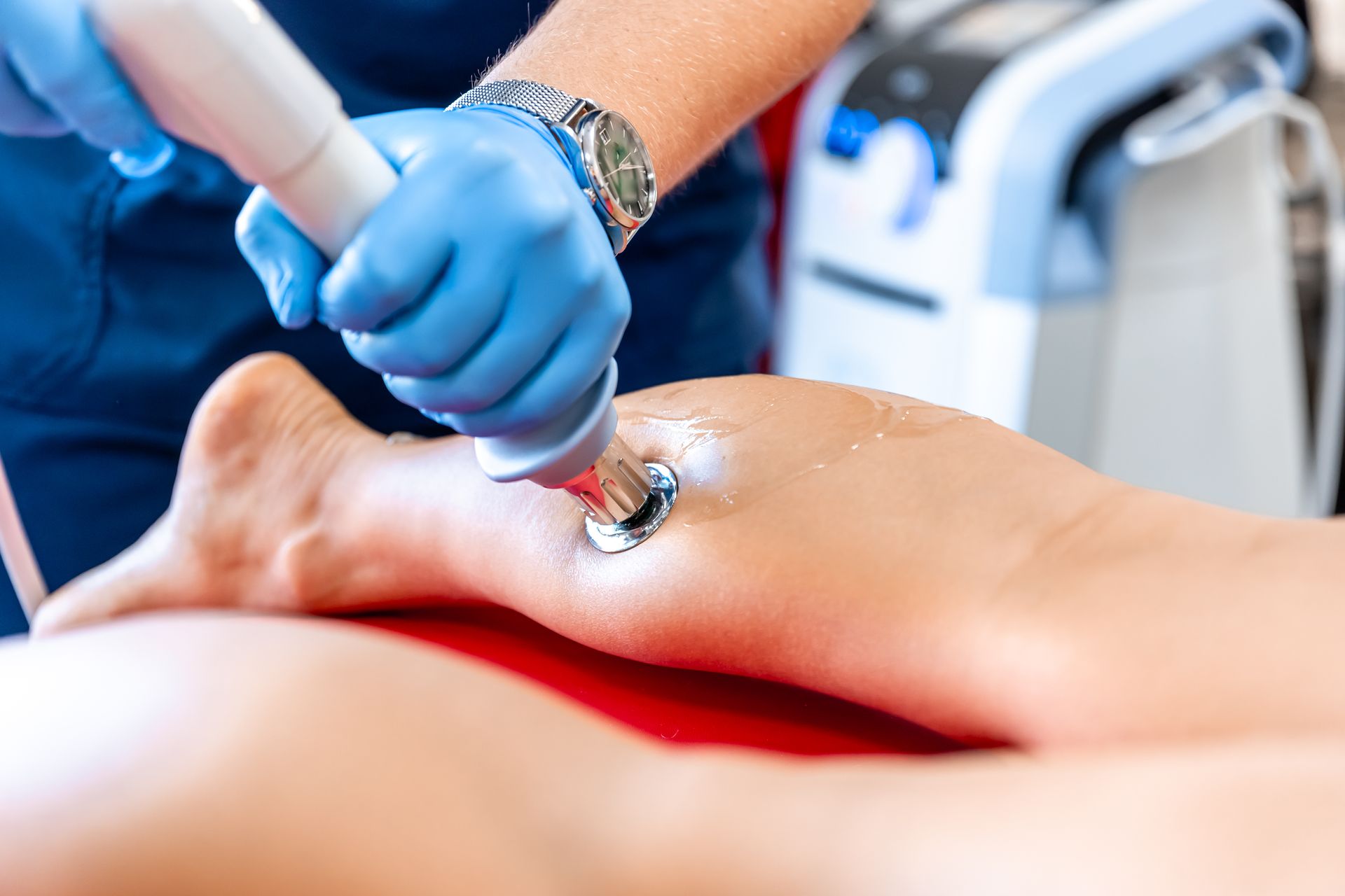 Gloved hands using a tool to clean a person’s foot with gel at a treatment station