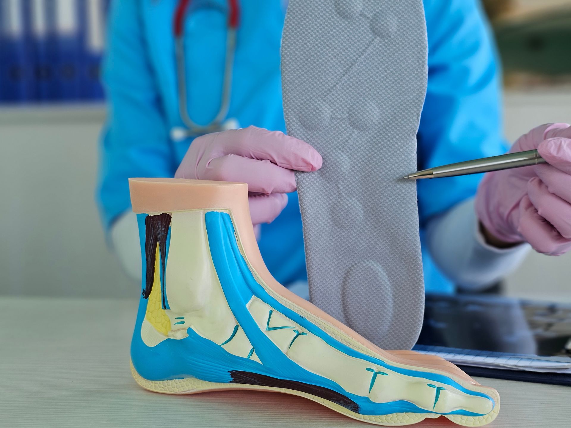Doctor holding a foot model with a leg brace, showing anatomy and support design