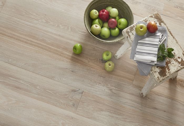 Wooden floor with a bowl of apples and a small stool.