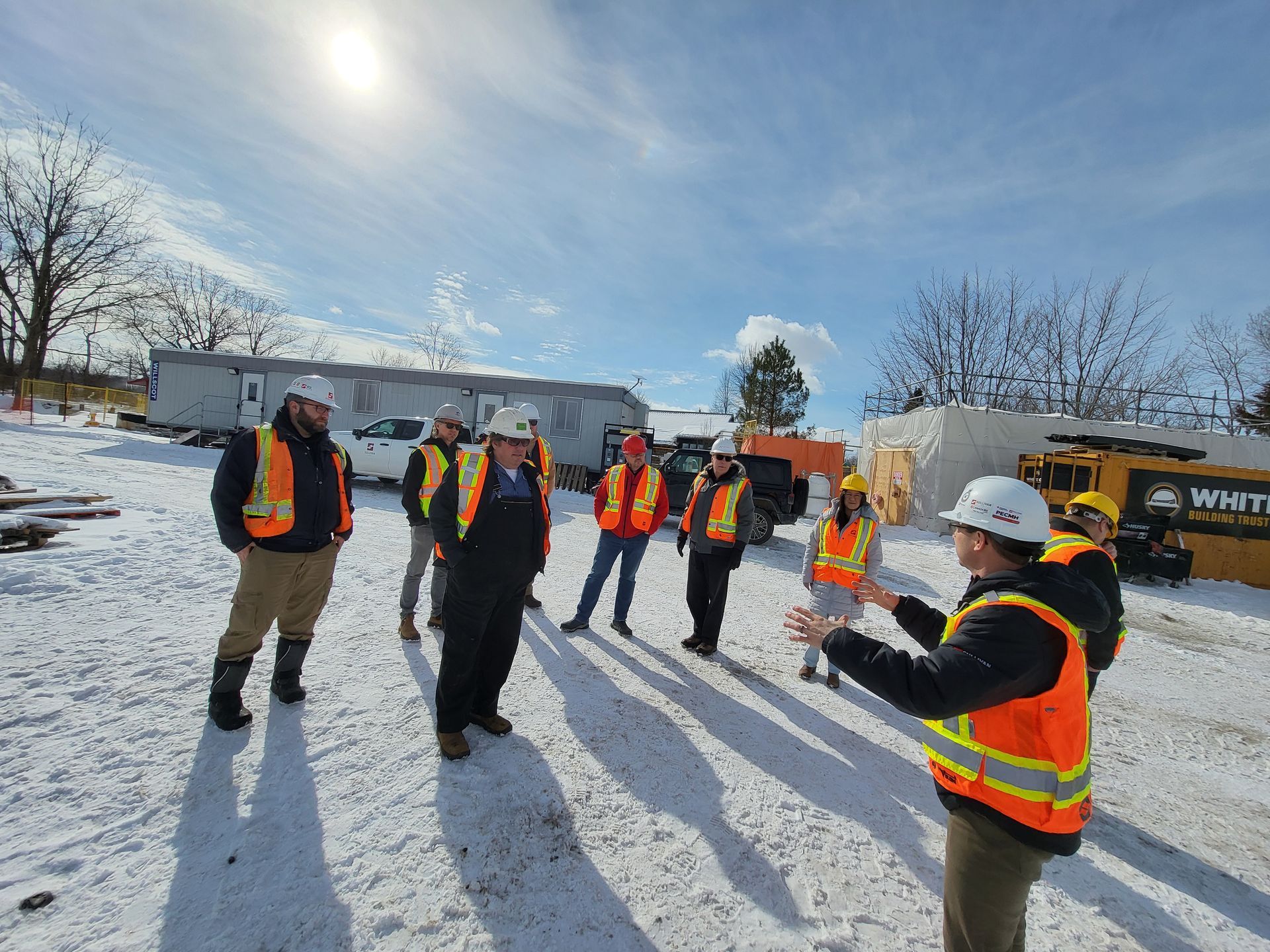 Contractors stand on the site of the new PECMH