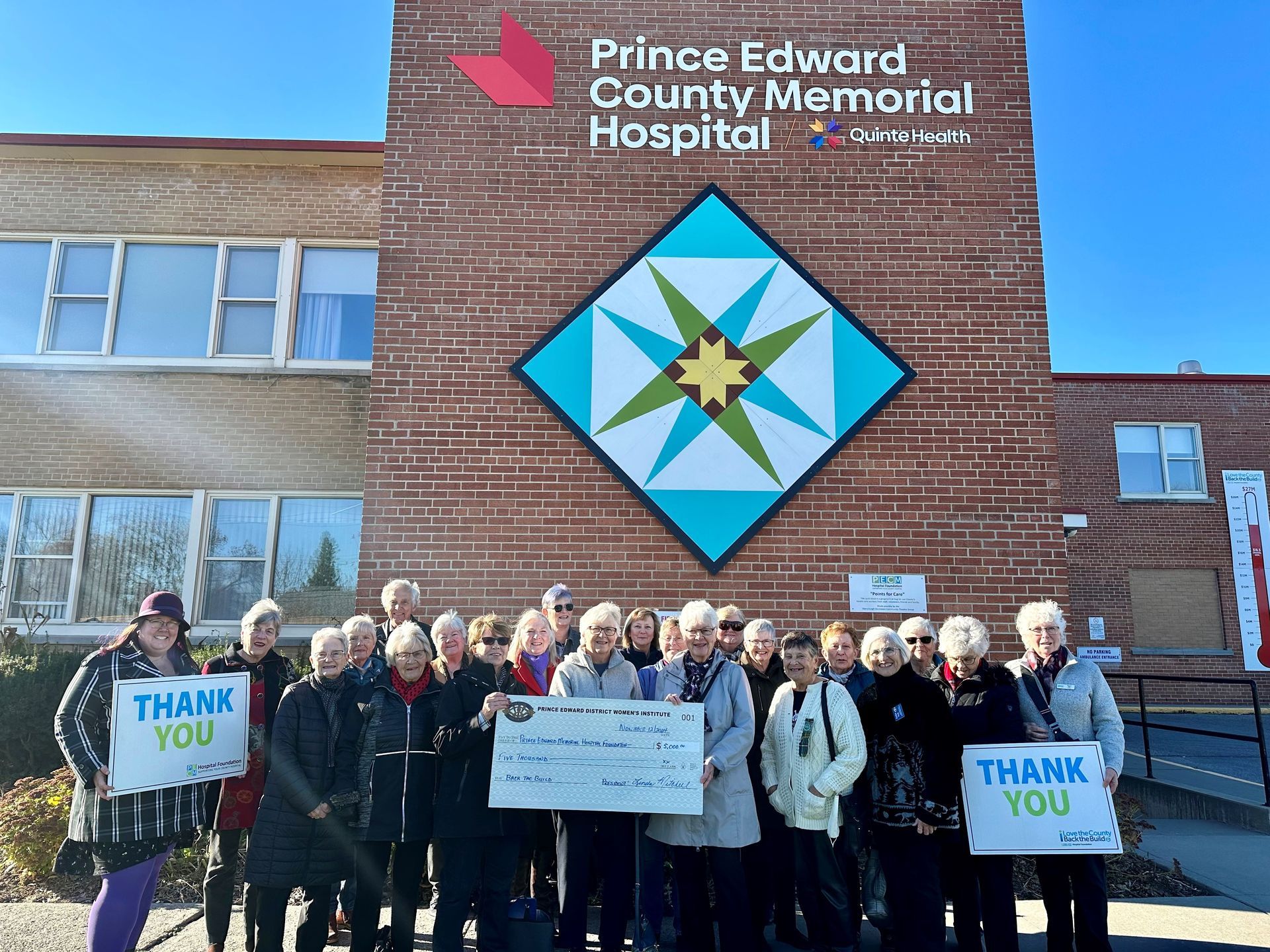 Members of the PEDWI and PECMHF pose in front of the current hospital.