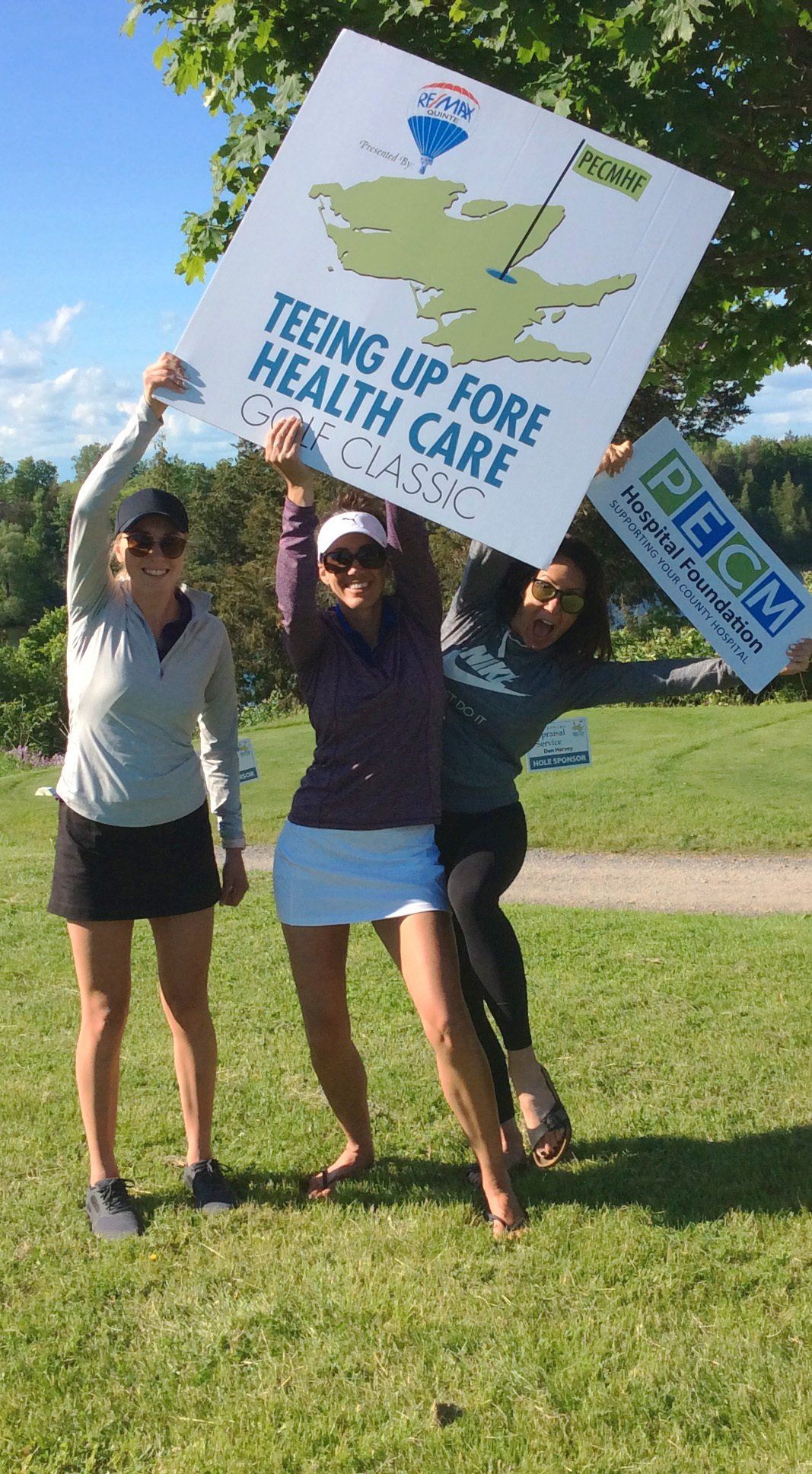 Golfers pose with PECMHF signs