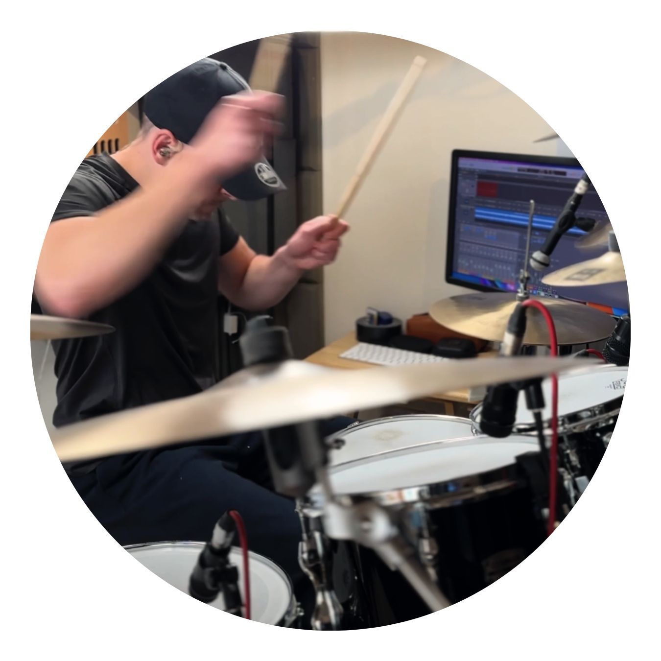 Drummer playing drums in a recording studio. Black and white photo.