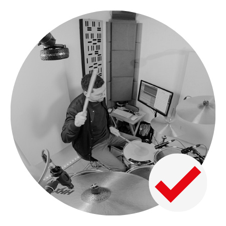 Drummer playing drums in a recording studio. Black and white photo.