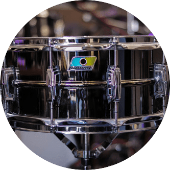 Chrome-plated Ludwig snare drum with logo, in a drum kit.
