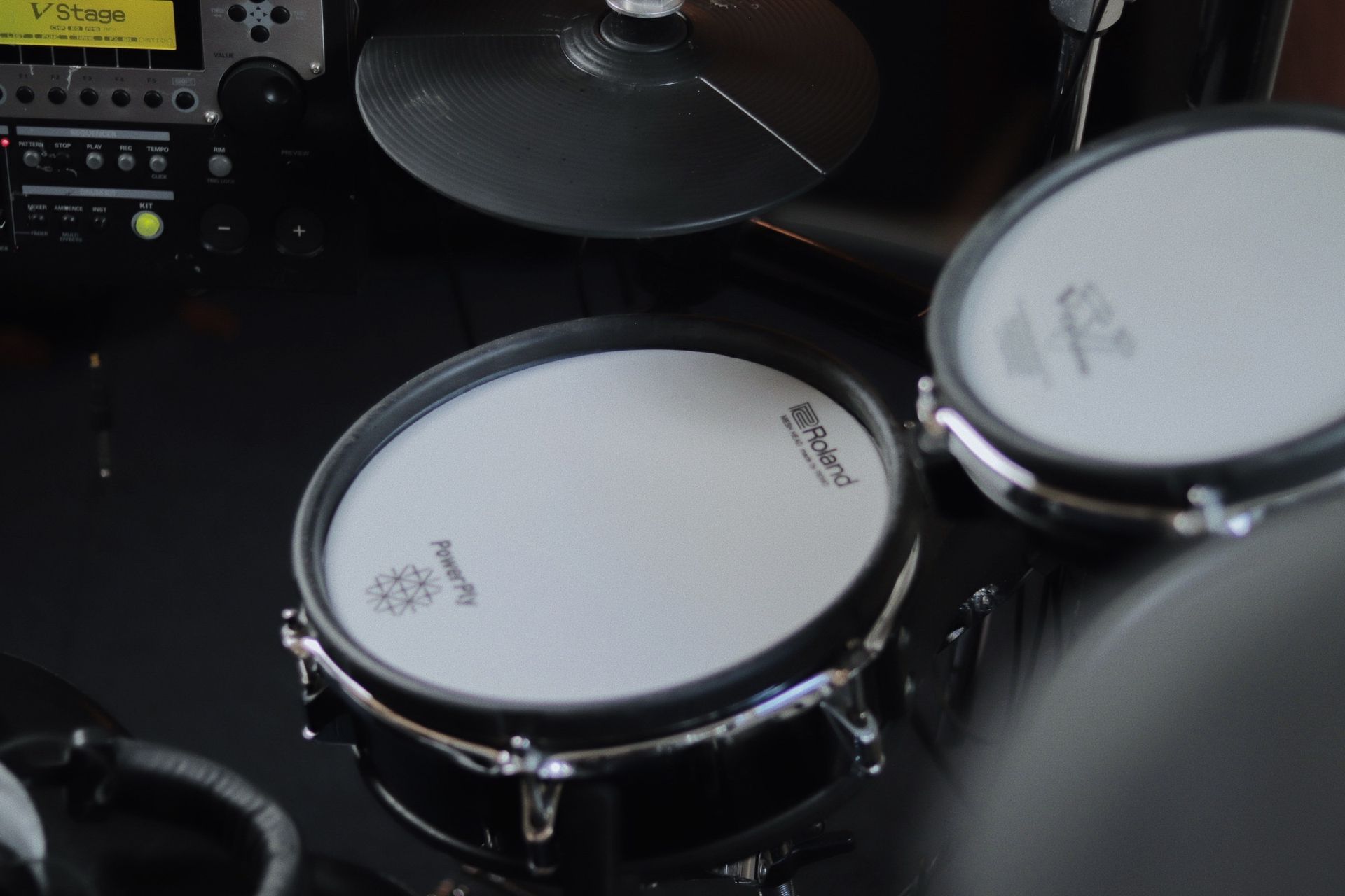 Drum set in a studio with microphones, sound panels, and Yamaha logo. Black and chrome drums.