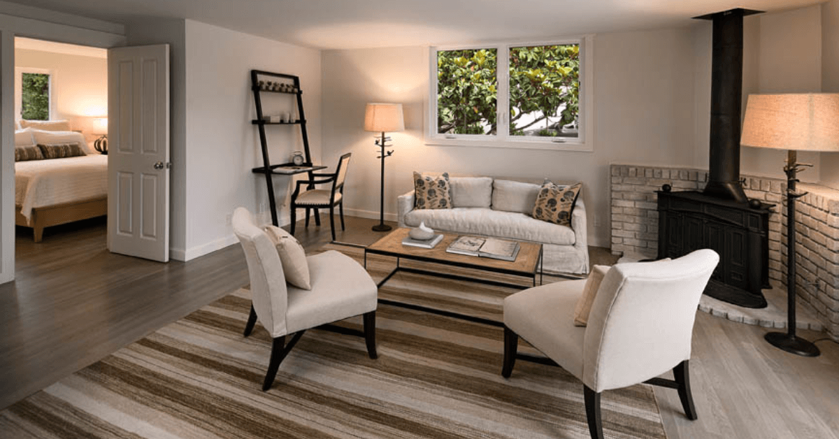 A living room with a couch , chairs , coffee table and fireplace.